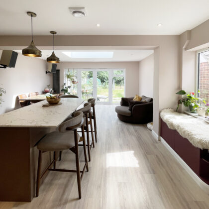 Spacious open-plan kitchen with central island connecting the cooking, dining and living areas in a renovated Whitstable home.